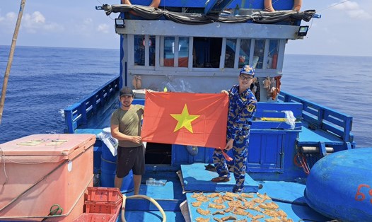 Lữ đoàn 125 - Vùng 2 Hải quân tặng cờ Tổ quốc cho tàu cá sau khi hỗ trợ. Ảnh: Hải quân