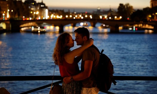 Cặp đôi hôn nhau vào thời điểm hoàng hôn trên cầu Pont des Arts bắc qua sông Seine ở Paris, Pháp. Ảnh: AFP