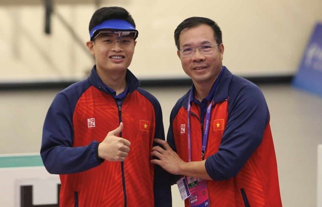 Xạ thủ Phạm Quang Huy (bên trái) và huấn luyện viên Hoàng Xuân Vinh. Ảnh: Nam Trung 