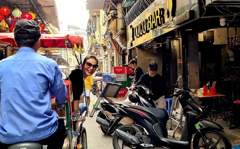 Khách du lịch ngắm phố cổ Hà Nội từ xích lô. Ảnh: Unsplash