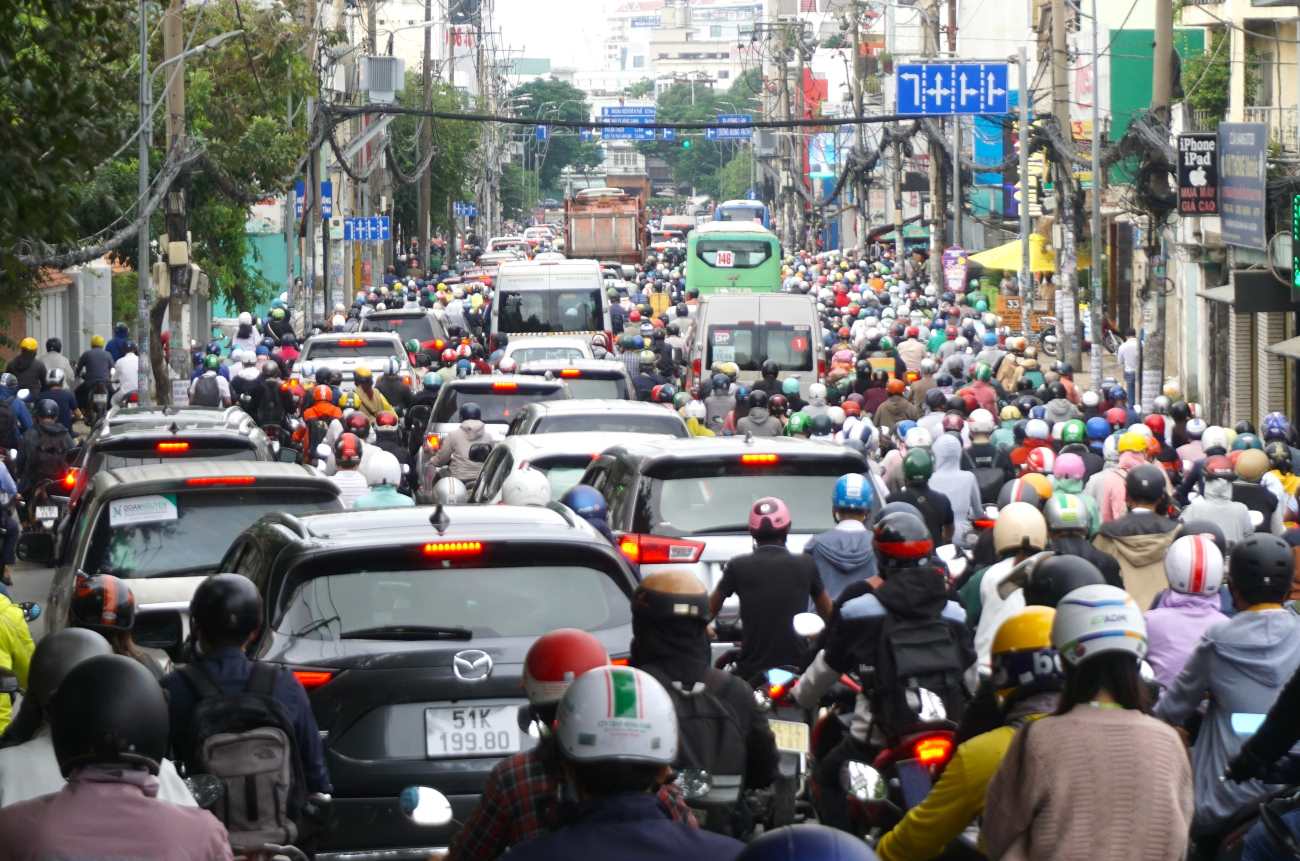 Giao thông hỗn loạn, xe máy, ô tô chen chúc, nhích từng chút một hướng vào trung tâm thành phố.