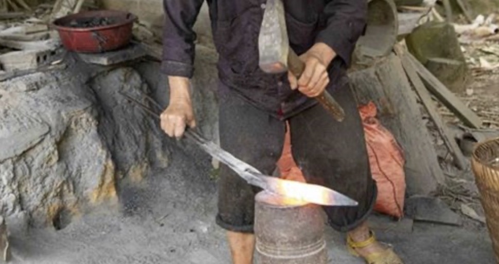 Lò rèn của người Mông không cầu kỳ, chỉ có một ụ đất làm lò, vài cục sắt to làm đe và một cái bễ. Ảnh: Anh Vũ