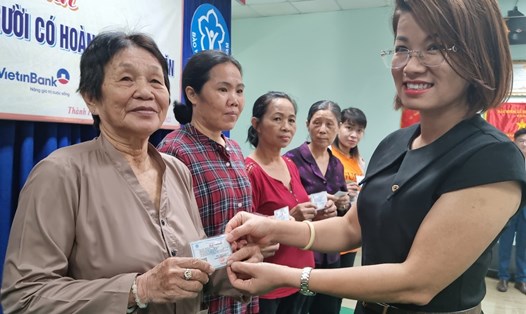 Đại diện nhà tài trợ trao thẻ BHYT hộ gia đình cho người dân có hoàn cảnh khó khăn trên địa bàn TP.Thủ Đức (TP Hồ Chí Minh). Ảnh: Nam Dương