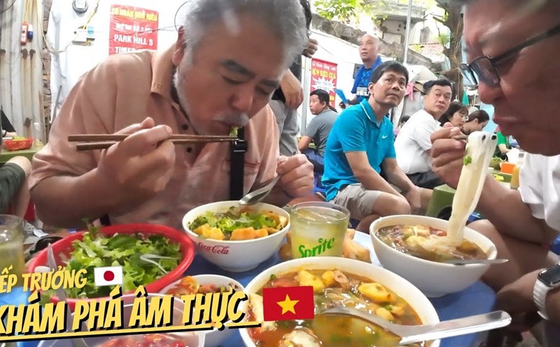 Hai thực khách người Nhật Bản thưởng thức món bún riêu cua tại phố cổ Hà Nội. Ảnh: KiKi.JP