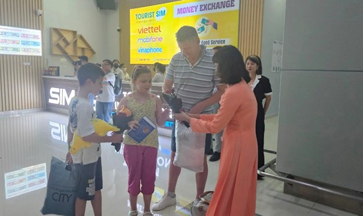 Đại diện Trung tâm Xúc tiến đầu tư thương mại và du lịch tỉnh Kiên Giang tặng hoa cho các du khách quốc tế vừa hạ cánh xuống sân bay Phú Quốc. Ảnh: Xuân Nhi
