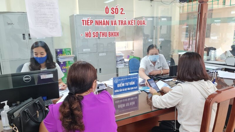 Cán bộ BHXH Việt Nam hướng dẫn người dân cài đặt ứng dụng VssID-BHXH số. Ảnh: BHXHVN