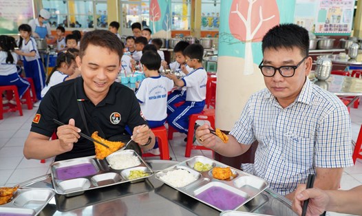 Anh Mạnh Hiền (áo đen) cùng các phụ huynh ăn cơm bán trú tại trường. Ảnh: Chân Phúc