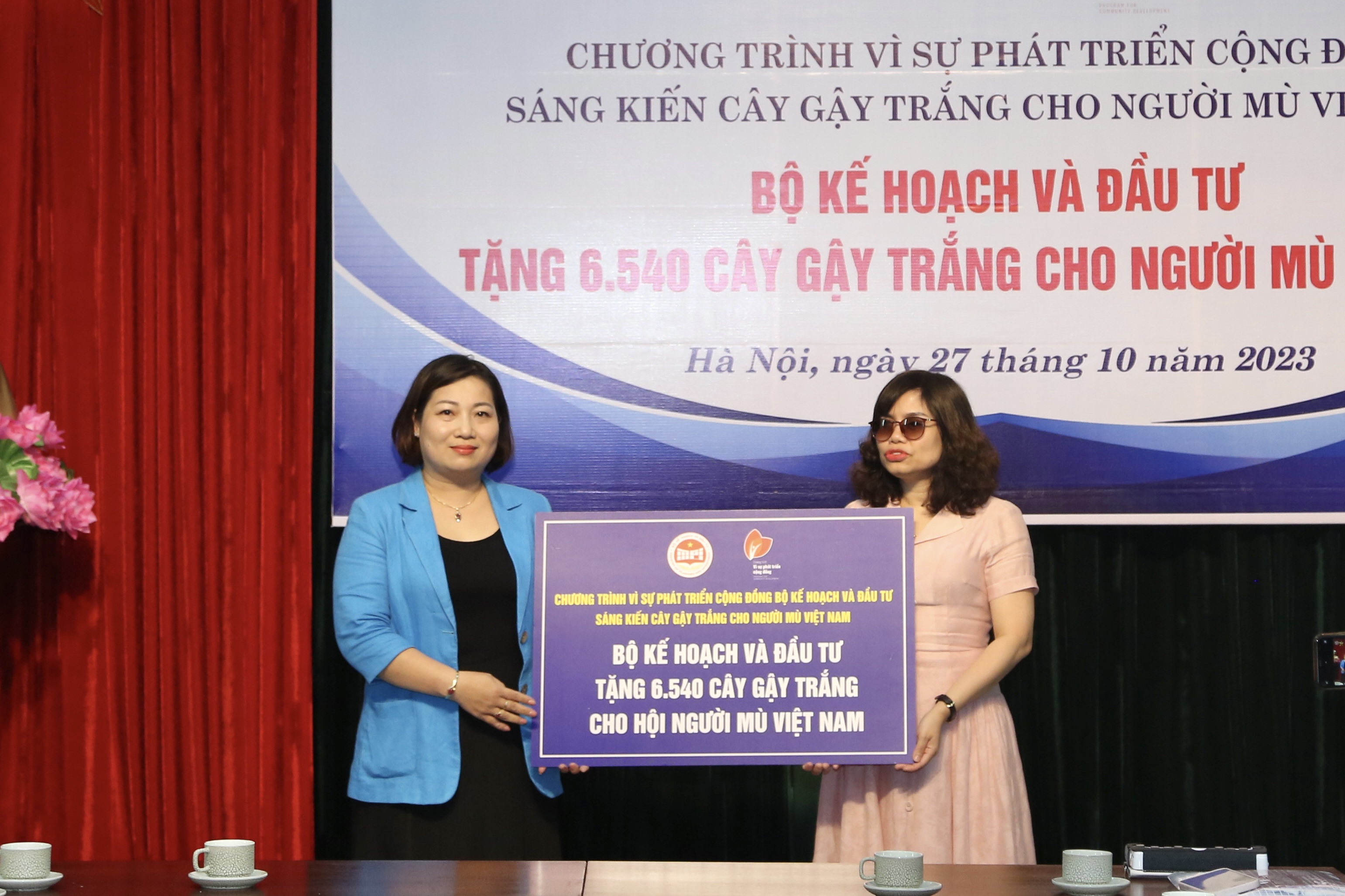 Bà Lê Thị Tường Thu (bên trái) thực hiện nghi thức trao tặng 6.540 cây gậy trắng cho đại diện Hội người mù Việt Nam. Ảnh: Thục Anh 