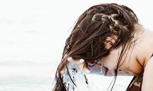 Gội đầu bằng nước không dùng dầu gội đầu là cách bảo vệ tóc bạn nên thử. Ảnh: Xinhua
