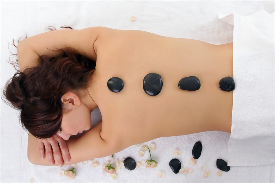Massage và chườm nóng sẽ phần nào giúp làm dịu cơn đau lưng nhanh chóng. Ảnh: Xinhua
