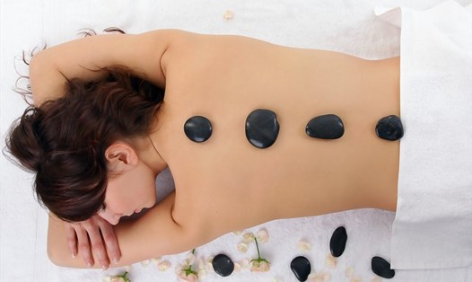 Massage và chườm nóng sẽ phần nào giúp làm dịu cơn đau lưng nhanh chóng. Ảnh: Xinhua
