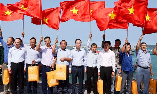Chủ tịch nước Võ Văn Thưởng tặng cờ Tổ quốc cho ngư dân tại khu neo đậu tránh trú bão, huyện đảo Cô Tô, Quảng Ninh. Ảnh: TTXVN