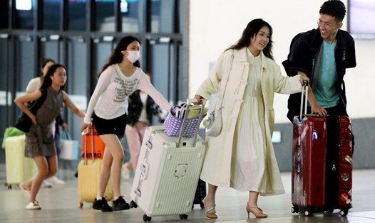 Một gia đình chuẩn bị làm thủ tục khởi hành tại sân bay ở Trung Quốc. Ảnh: Xinhua