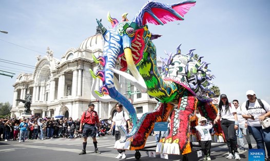 Trong hình là một sinh vật Alebrije, đầu rồng nhưng mang vòi và ngà voi, mình ốc sên đang diễu hành trên phố. Ảnh: Xinhua