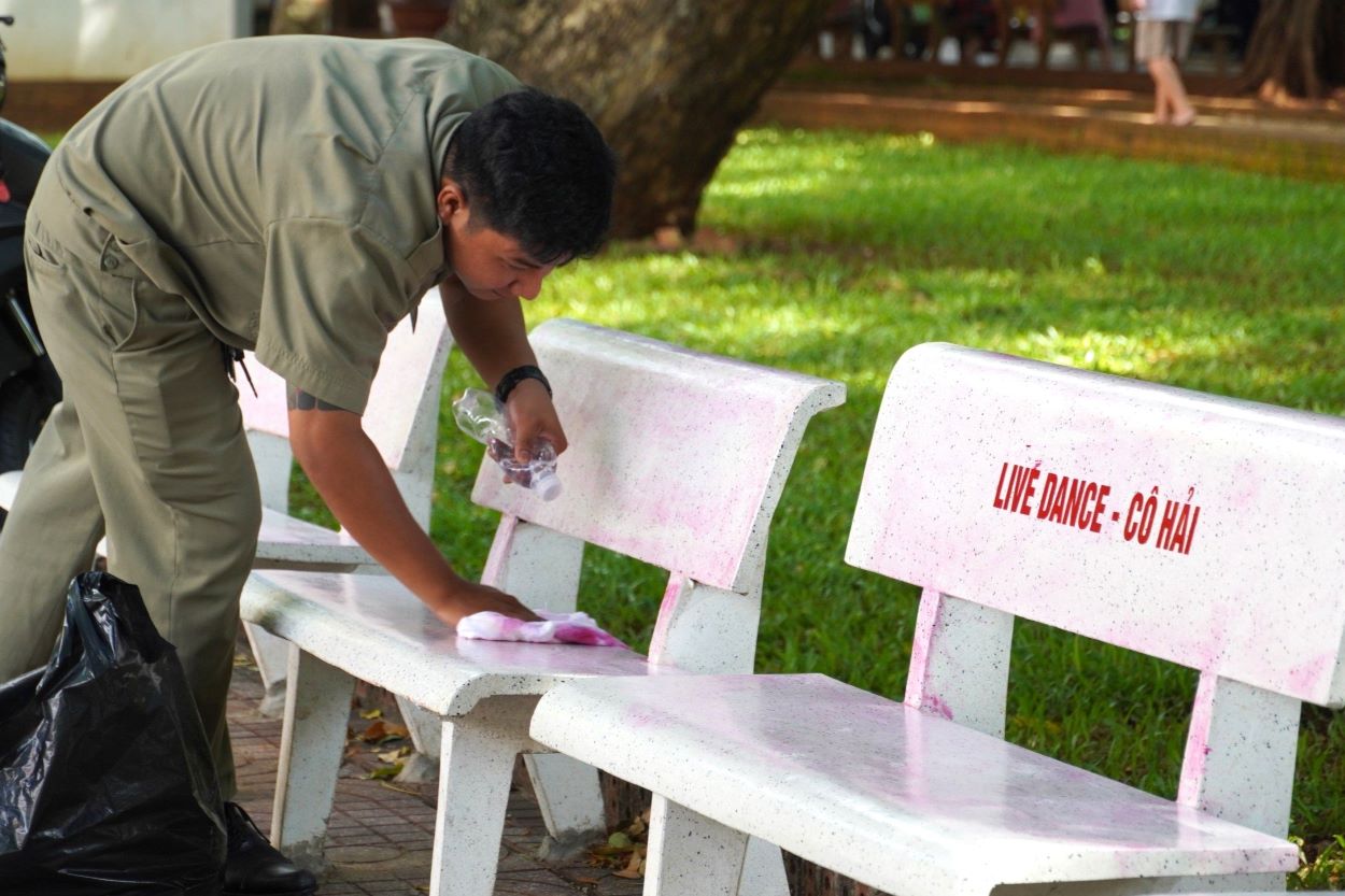Lực lượng chức năng tiến hành vệ sinh các ghế đá trong công viên. Ảnh: Hoàng Ngọc