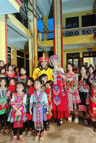 Vợ chồng Lê Văn Phú cạnh các học sinh trường dân tộc 