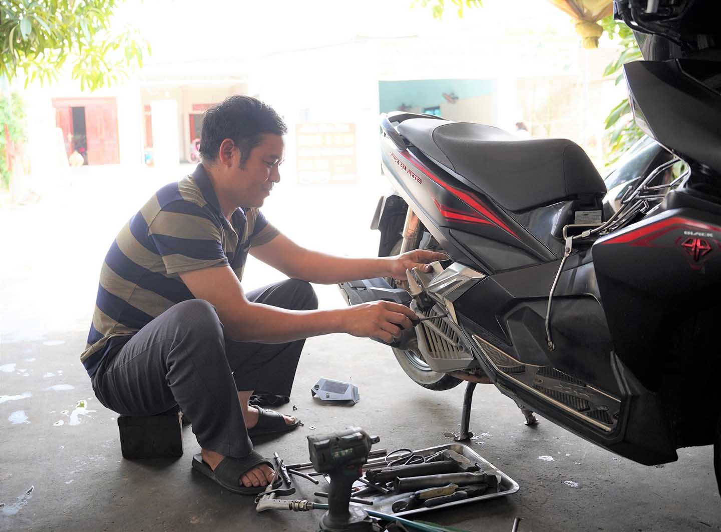 Anh Đoàn văn Kim làm nghề sửa xe máy ở xã Quỳnh Dị, thị xã Hoàng Mai. Ảnh: Duy Chương