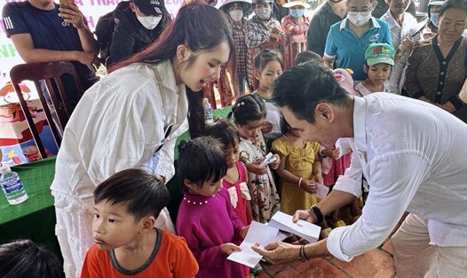 Lý Hải - Minh Hà trao quà tại làng chiếu Định Yên. Ảnh: NSCC