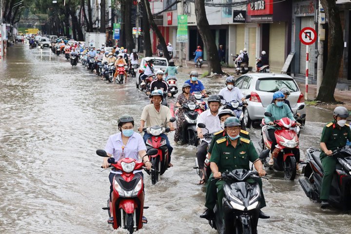 Người dân chật vật di chuyển phía bên ít ngập của đường Nguyễn Trãi. Ảnh: Yến Phương