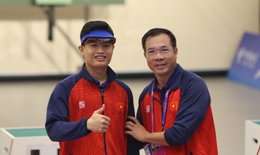 Xạ thủ Phạm Quang Huy (bên trái) và huấn luyện viên Hoàng Xuân Vinh. Ảnh: Bùi Lượng 