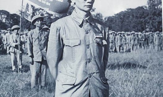 Bác sĩ Trần Duy Hưng trong lễ chào cờ chiến thắng, phía sau là lá cờ "Quyết chiến Quyết thắng". Ảnh: Tư liệu