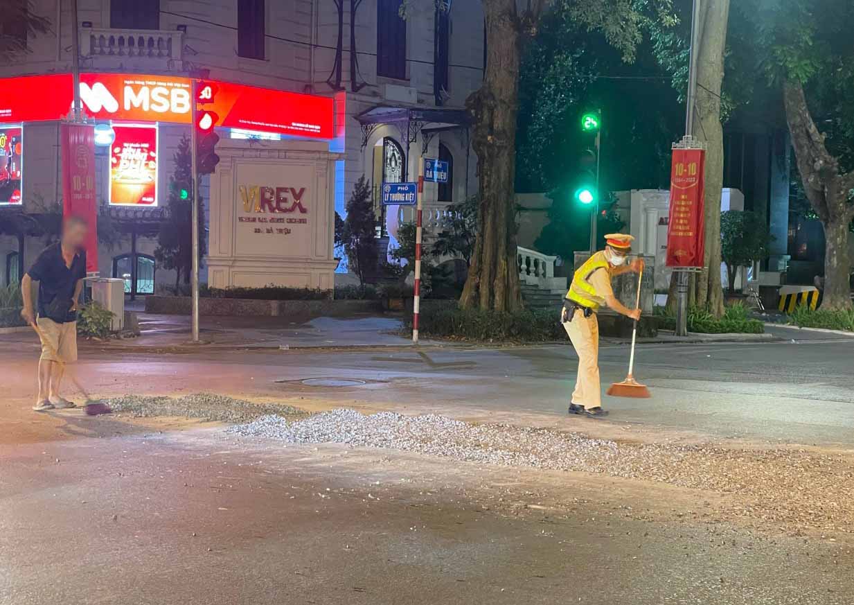 CSGT hỗ trợ tài xế dọn dẹp đất đá rơi trên đường. Ảnh: Công an cung cấp