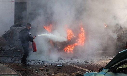 Lực lượng an ninh Israel dập lửa ở Ashkelon, miền nam Israel sau vụ tấn công bằng rocket do Hamas phát động từ Dải Gaza trong ngày 7.10. Ảnh: AFP