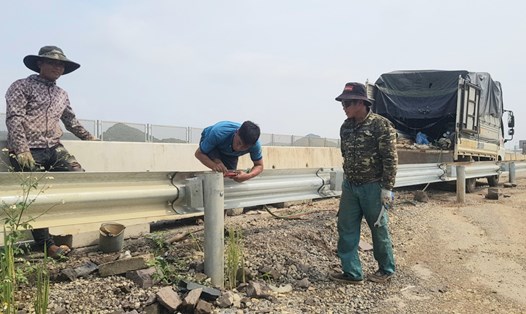 Lắp đặt lại phần lan can bị tháo dỡ trên tuyến cao tốc Mai Sơn - QL45, đoạn qua địa bàn thành phố Tam Điệp (ảnh chụp sáng 7.10). Ảnh: Diệu Anh