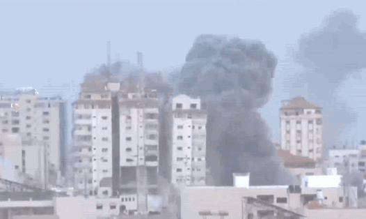 Hai tòa nhà đổ sập ở thành phố Gaza do trúng pháo kích hôm 7.10. Ảnh cắt từ video của AFP