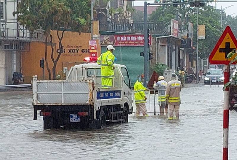 CSGT Thành phố Hà Tĩnh đặt biển cảnh báo đường ngập. Ảnh: Nam Tuấn.