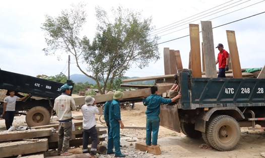 Lực lượng chức năng tỉnh Đắk Lắk giúp người dân vùng lòng hồ Krông Pách thượng dựng nhà, dọn đến khu tái định cư mới. Ảnh: Công Lý