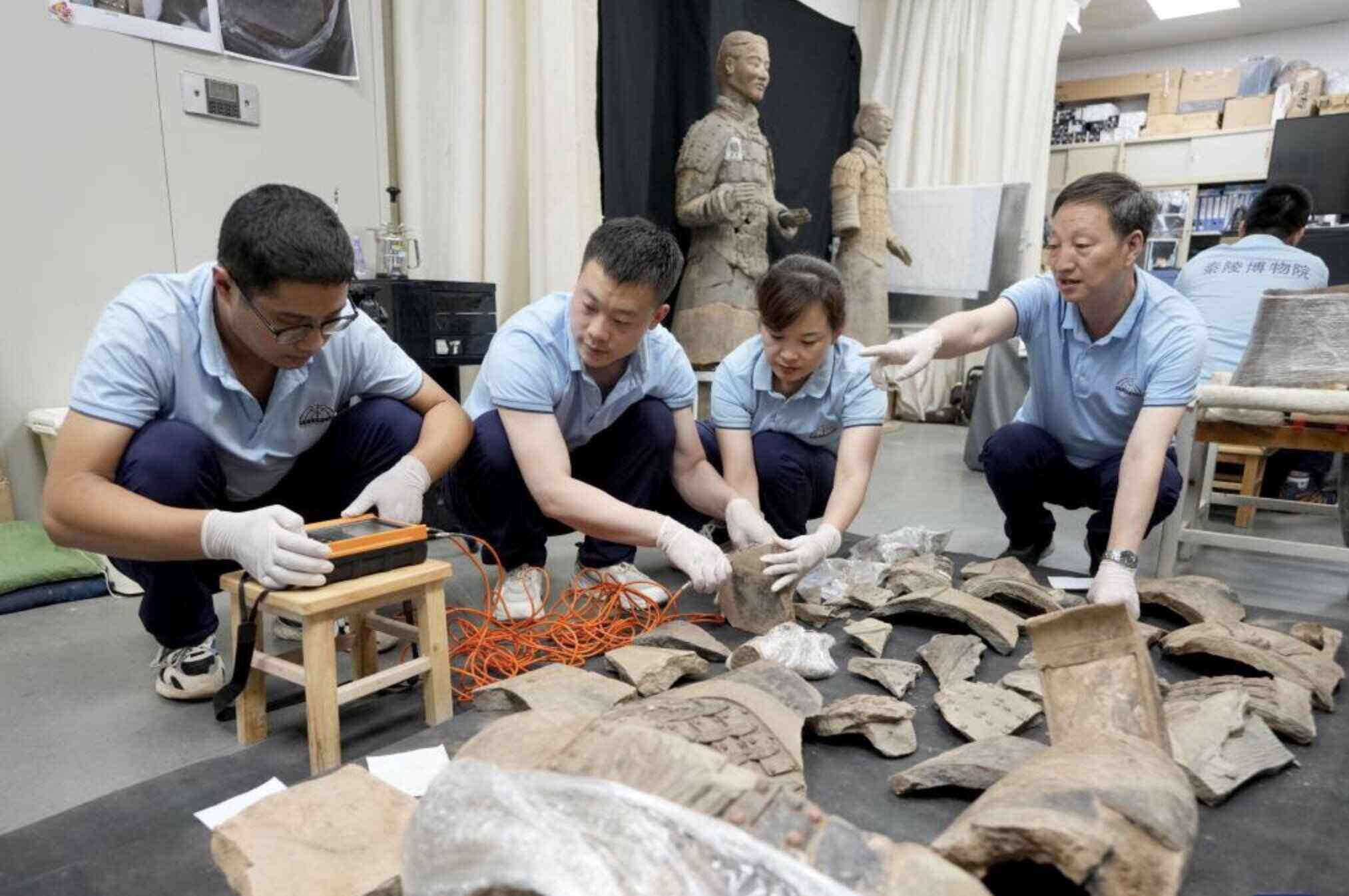 Các chuyên gia làm việc để phục chế bức tượng đất nung được khai quật từ lăng mộ Tần Thuỷ Hoàng. Ảnh: Xinhua