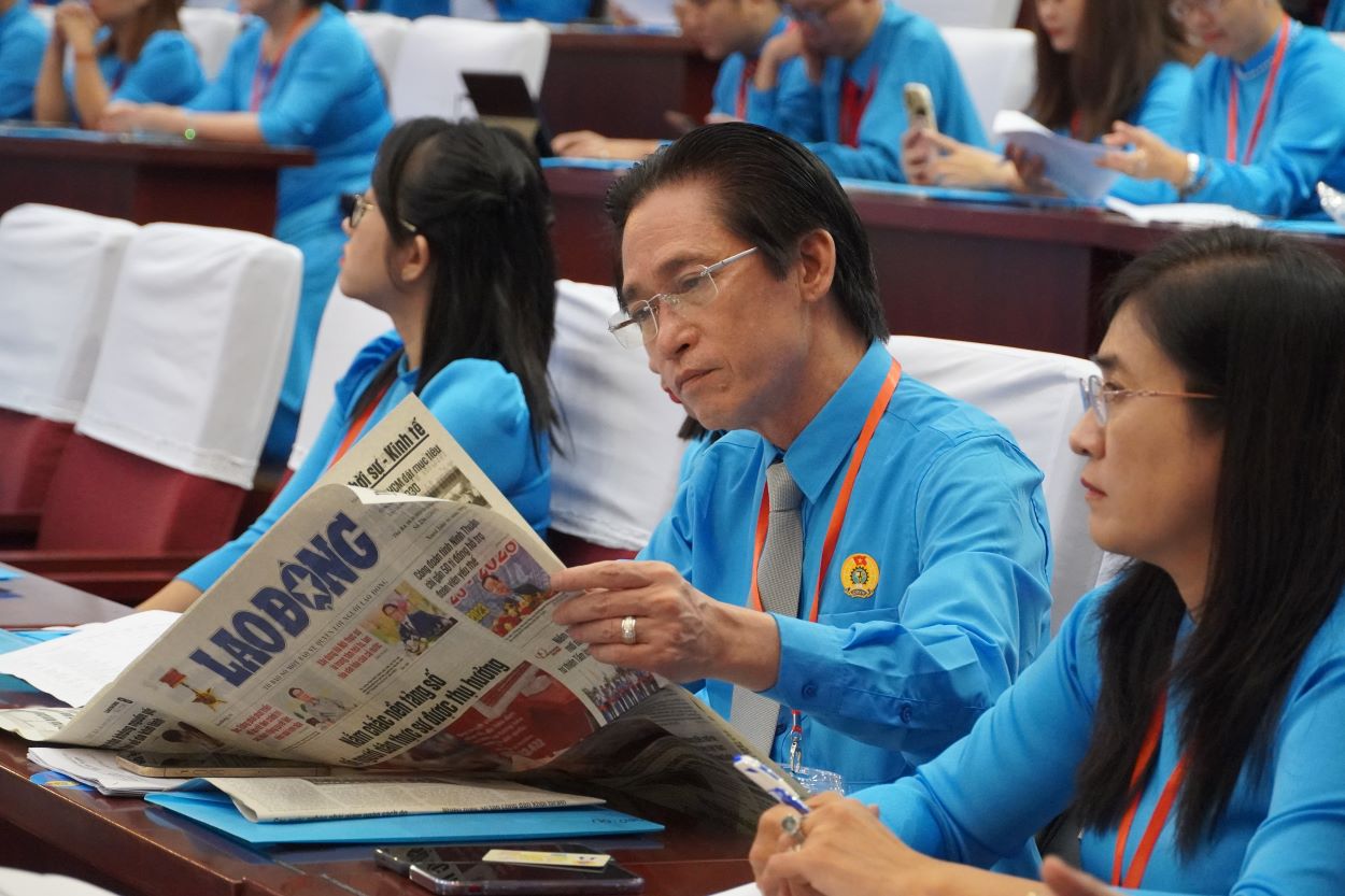 Các đại biểu đọc báo Lao Động trước khi bắt đầu Đại hội. Ảnh: Thành An