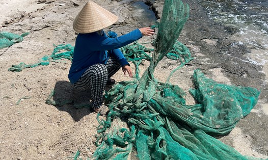 Hàng tấn rác lưới mùng đen kịt vây kín biển Cam Ranh. Ảnh: Hữu Long
