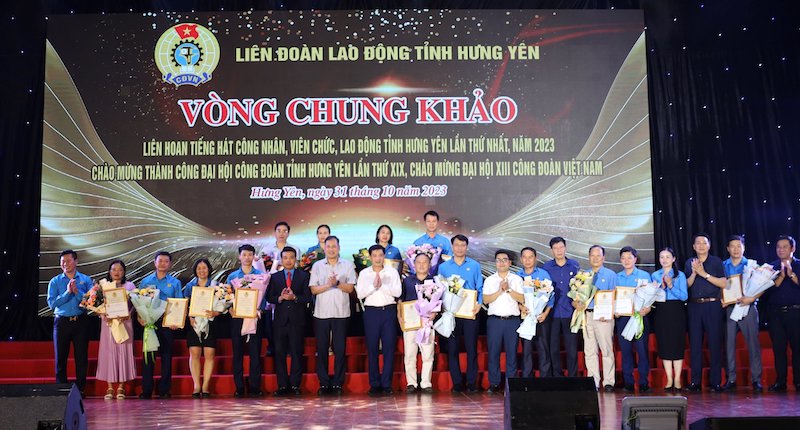 Đại diện Tổng LĐLĐ Việt Nam và LĐLĐ tỉnh Hưng Yên trao cờ lưu niệm cho 18 đơn vị tham gia Liên hoan. Ảnh: Hưng Yên