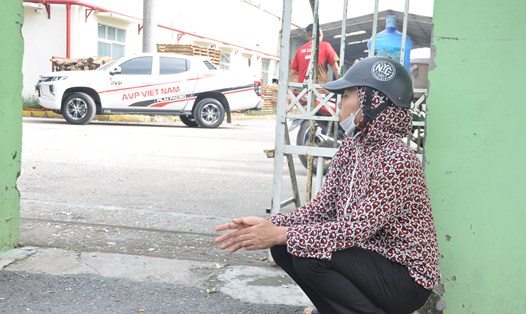 Một nữ công nhân lo lắng ngồi trước cổng Công ty TNHH T.T.B Việt Nam MFG ngóng chờ vụ việc được giải quyết (ảnh chụp ngày 9.11). Ảnh: Quế Chi
