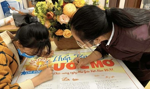 Học sinh trang trí báo tường dành tặng thầy cô nhân ngày Nhà giáo Việt Nam 20.11. Ảnh: LĐO