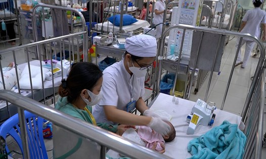 Bệnh nhi được bác sĩ chăm sóc tại Bệnh viện Nhi đồng 2. Ảnh: Hương Sơn