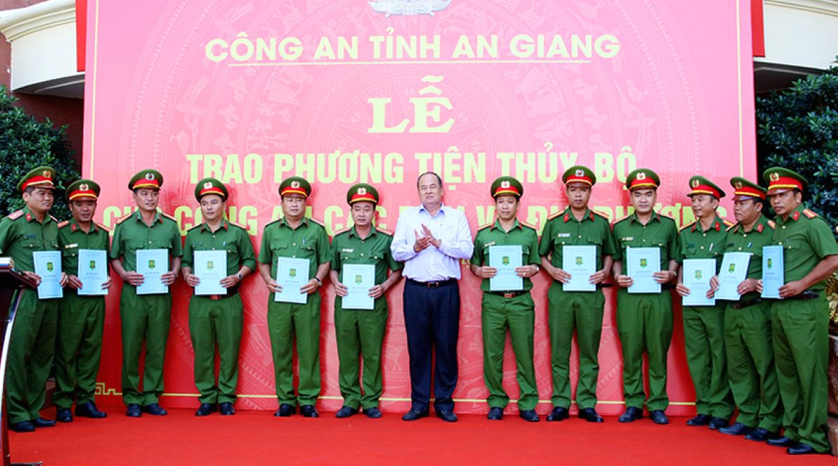 Chủ tịch UBND tỉnh An Giang Nguyễn Thanh Bình trao Quyết định trang bị xe ô tô tải cho Công an các xã, thị trấn. Ảnh: Vũ Tiến