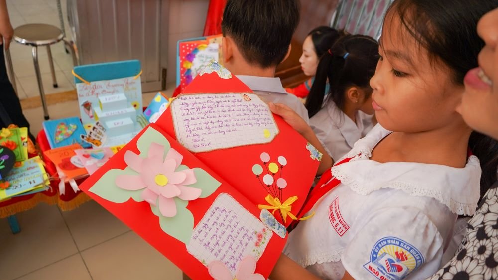 Nguyễn Hà Minh Anh (học sinh lớp 4.1 - Trường Tiểu học Ngô Quyền) chia sẻ: “Con rất vui và háo hức khi được làm thiệp tặng thầy cô. Ý tưởng của con là vẽ trang trí cảnh các em học sinh tặng hoa cho thầy cô trong chiếc thiệp. Trong quá trình làm con đã được các cô sinh viên thực tập hướng dẫn, hỗ trợ con rất nhiều”.