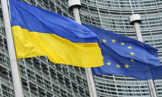 Cờ Ukraina (trái) và cờ EU bên ngoài trụ sở Ủy ban châu Âu ở Bỉ. Ảnh: Xinhua