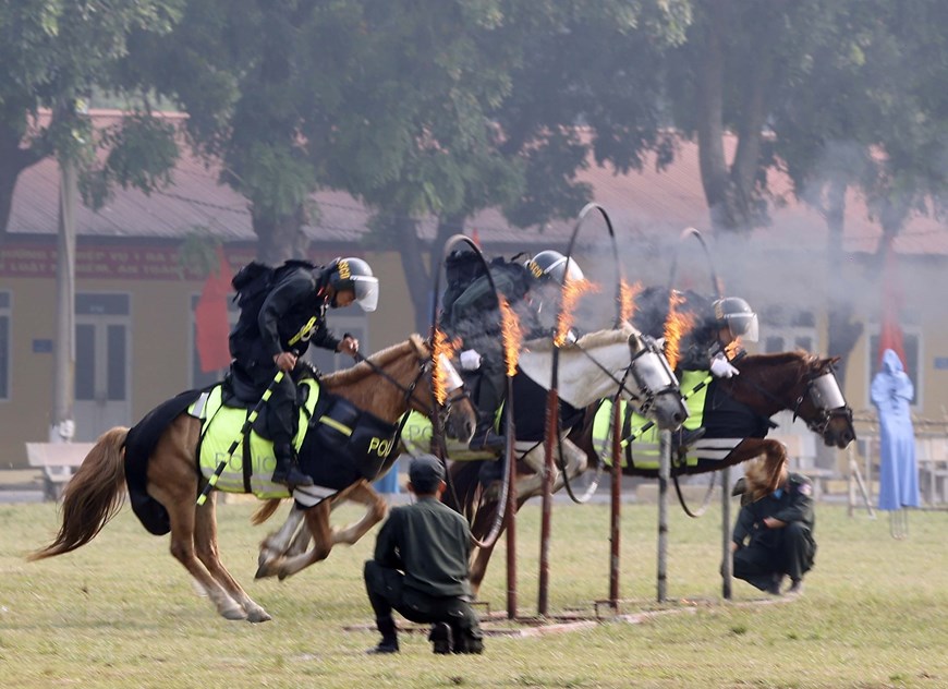 Các chiến sĩ Cảnh sát cơ động Kỵ binh biểu diễn nhảy qua vòng lửa. Ảnh: TTXVN