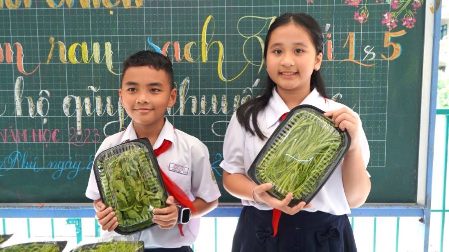 Kim Ngọc và Trung Kiên (học sinh lớp 5/3) tỏ ra thích thú, hào hứng khi lần đầu được tham gia bán rau trải nghiệm tại trường. 