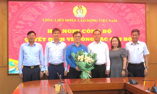 Thường trực Đoàn Chủ tịch Tổng LĐLĐVN tặng hoa chúc mừng ông Vũ Minh Tiến. Ảnh: Hà Anh