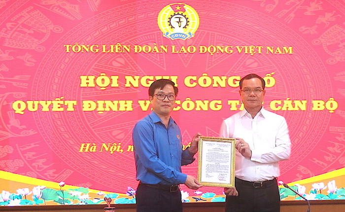 Chủ tịch Tổng LĐLĐVN Nguyễn Đình Khang trao Quyết định của Đoàn Chủ tịch cho ông Vũ Minh Tiến (bên trái). Ảnh: Hà Anh