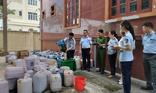 Lực lượng Quản lý thị trường tỉnh Ninh Bình phối hợp với các đơn vị liên quan tiến hành tiêu hủy gần 4.000 lít rượu không rõ nguồn gốc, xuất xứ. Ảnh: Diệu Anh 