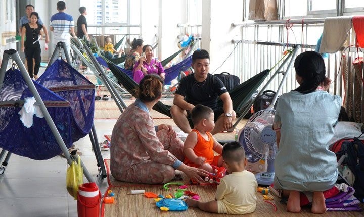 Bệnh nhi, người nhà trải chiếu, giăng võng nằm ngoài hành lang Bệnh viện Nhi đồng Cần Thơ. Ảnh: Mỹ Ly