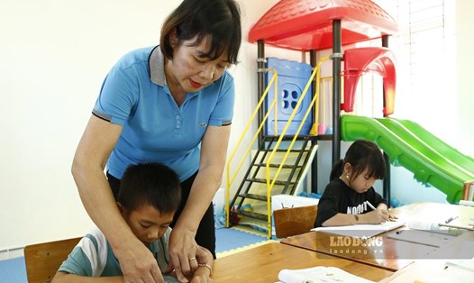 Cô giáo Phạm Thị Vường đang rèn nét chữ cho học sinh tại Phân hiệu trường liên cấp Thanh Lân tại đảo Trần. Ảnh: Thu Báu