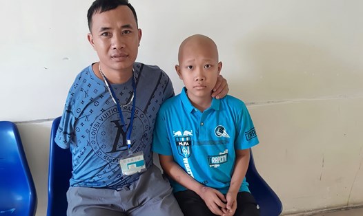 Nam công nhân Nguyễn Ngọc Bách cùng con trai trong thời gian chạy chữa bệnh ung thư thận ở Bệnh viện K. Ảnh: Thu Thuỷ