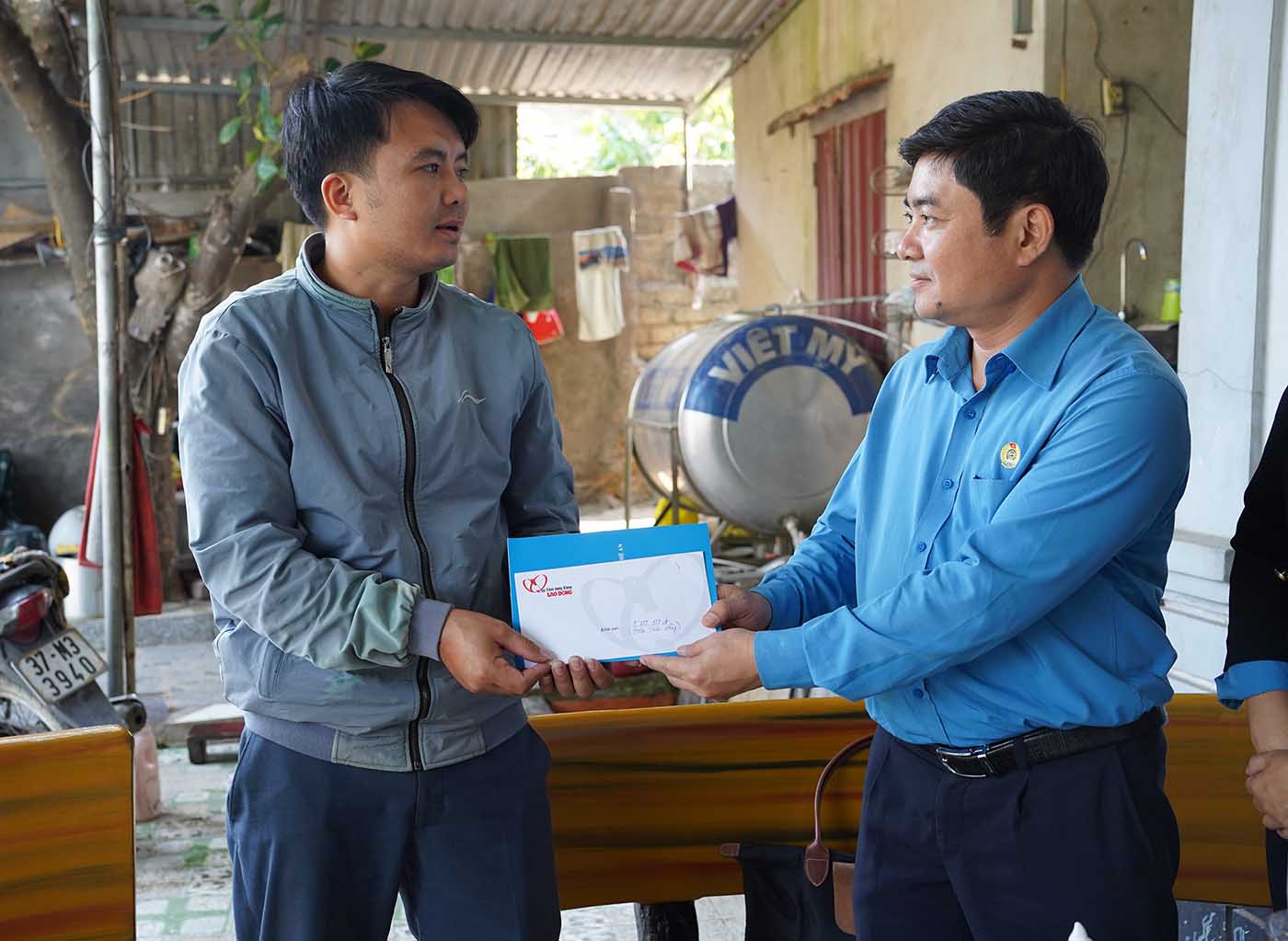 Trưởng Đoàn công tác trao hỗ trợ 5 triệu đồng từ Quỹ Tấm lòng Vàng cho anh Dương Văn Chính, xóm 1, xã Nghi Đồng. Ảnh: Quang Đại